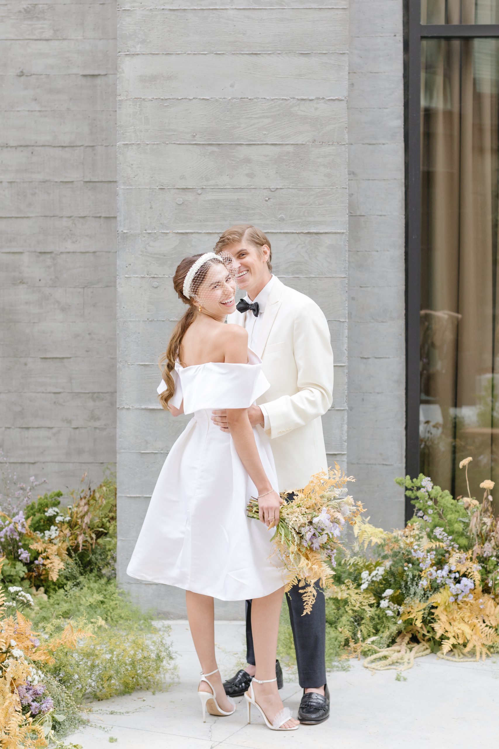 brie and groom posing with flowers