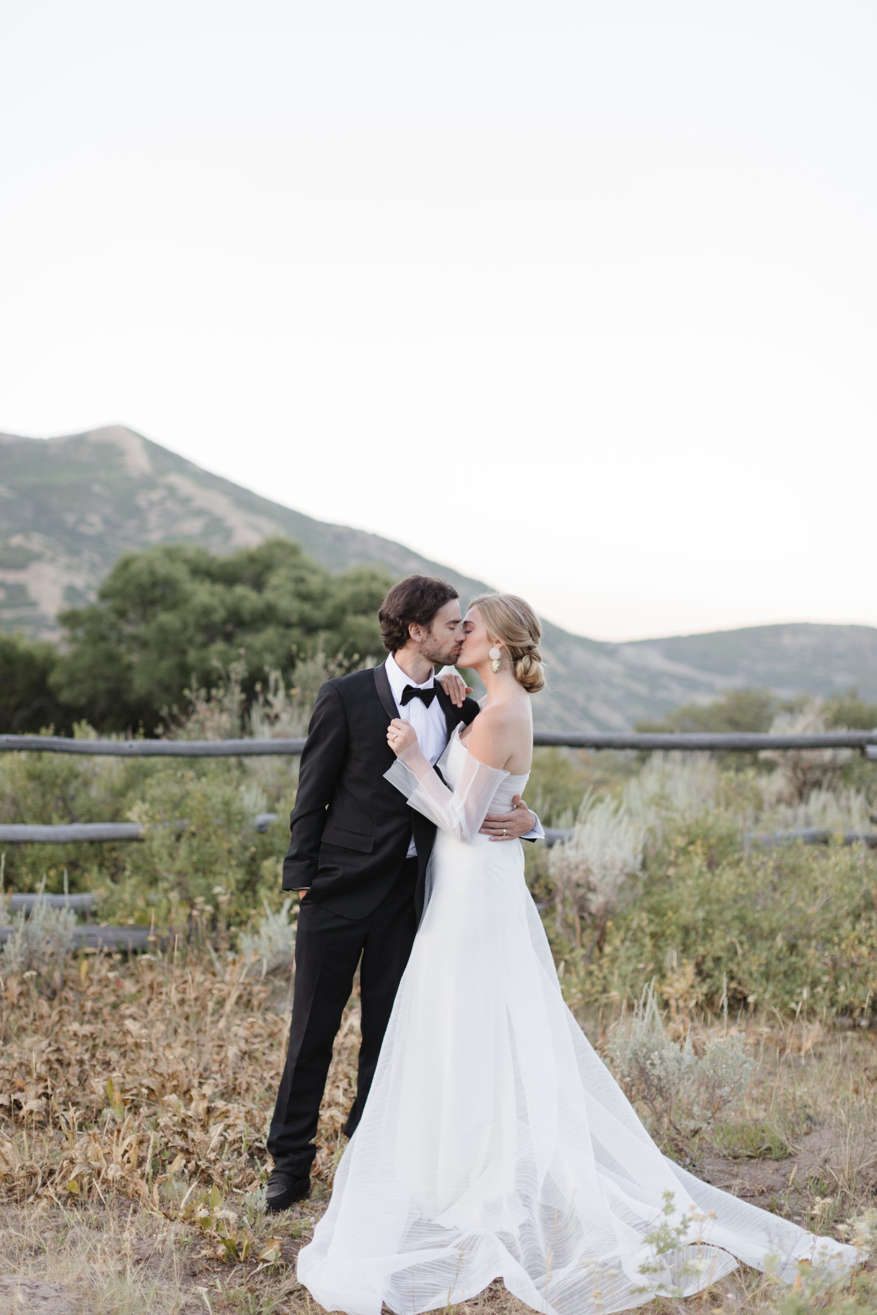 couple kissing on their wedding day with the mountains in the background