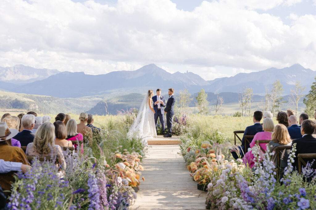 Mountain-top wedding ceremony with wildflower aisle. 