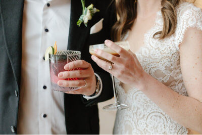 bride and groom holding their craft cocktails at their wedding