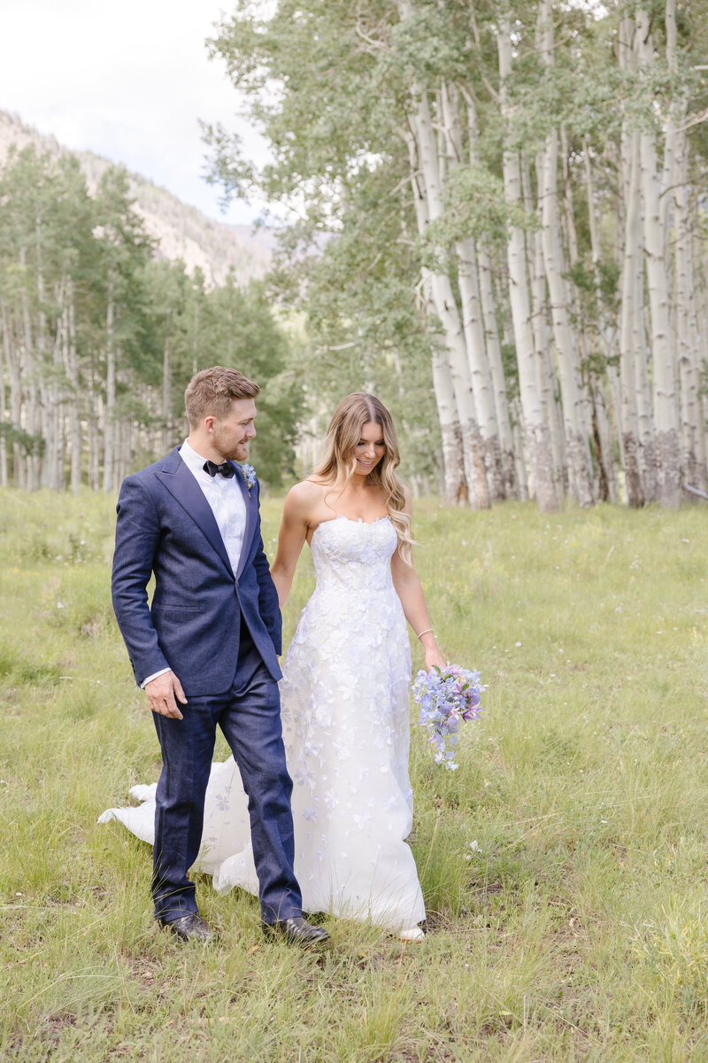 couple walking through the grass as husband and wife