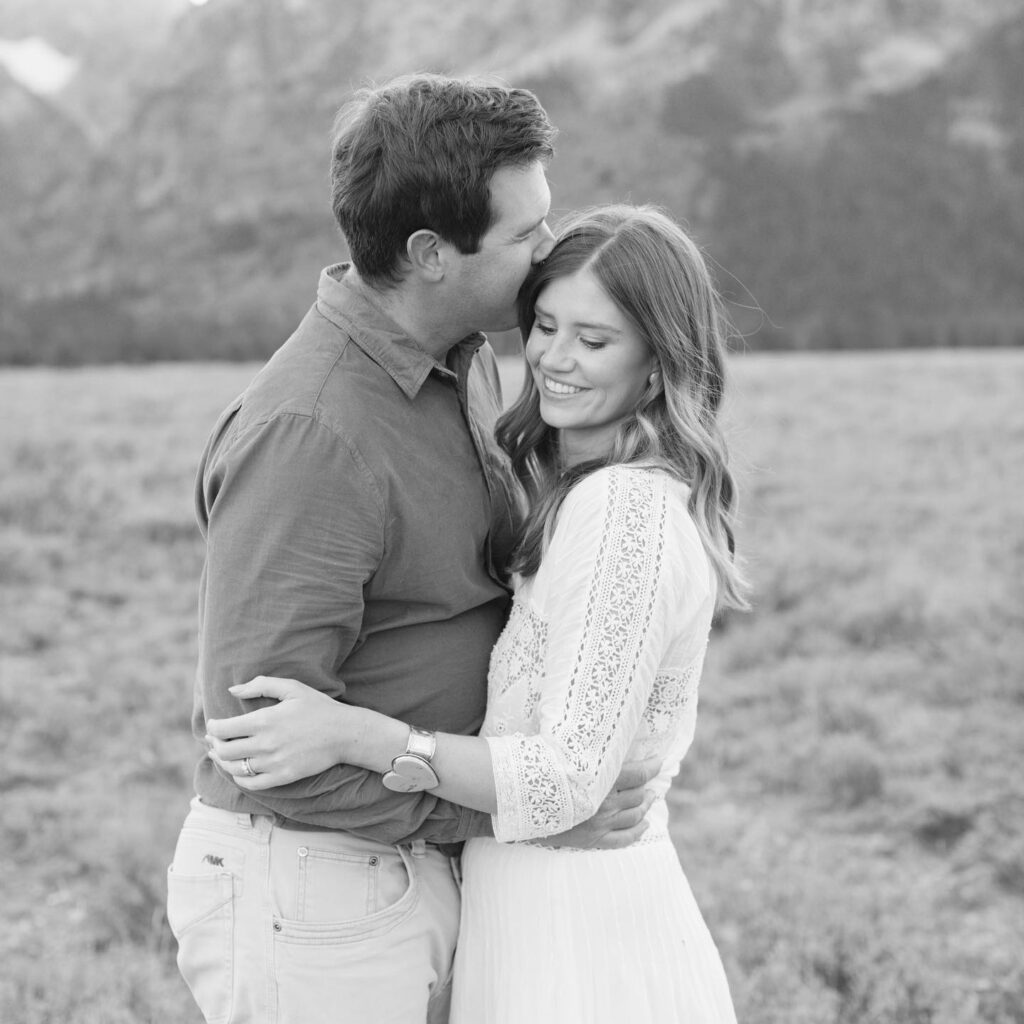 black and white photo of a couple during their engagement photo ideas with mountains in the background