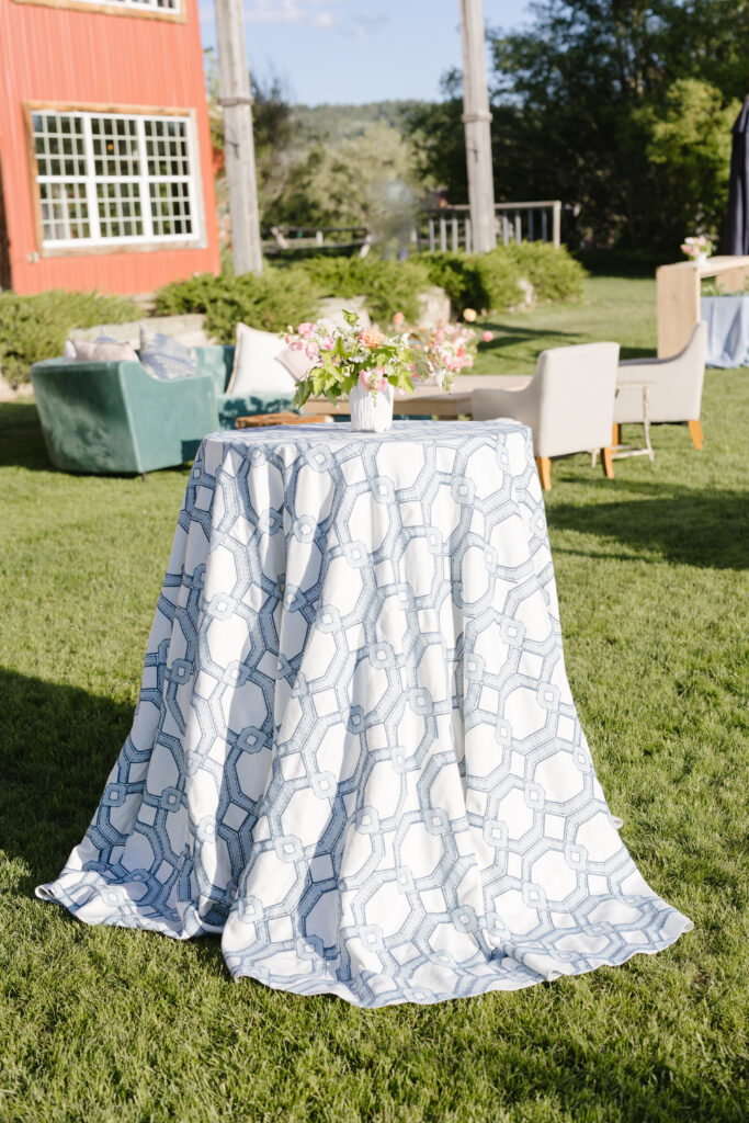 floral blue and white table cloth over the cocktail hour table in the garden