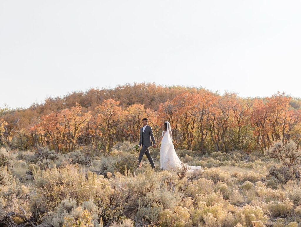 eloping-in-jackson-hole bride and groom walking through the autumn colors while eloping with family