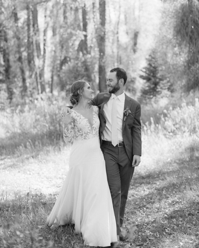 eloping-in-jackson-hole bride and groom walking through the trees during their elopement