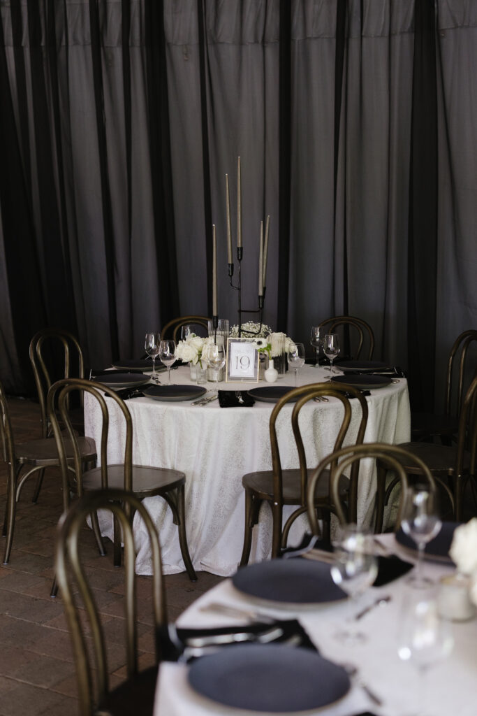 Modern black and white reception table with tall taper candles and minimalist florals for a chic celebration.