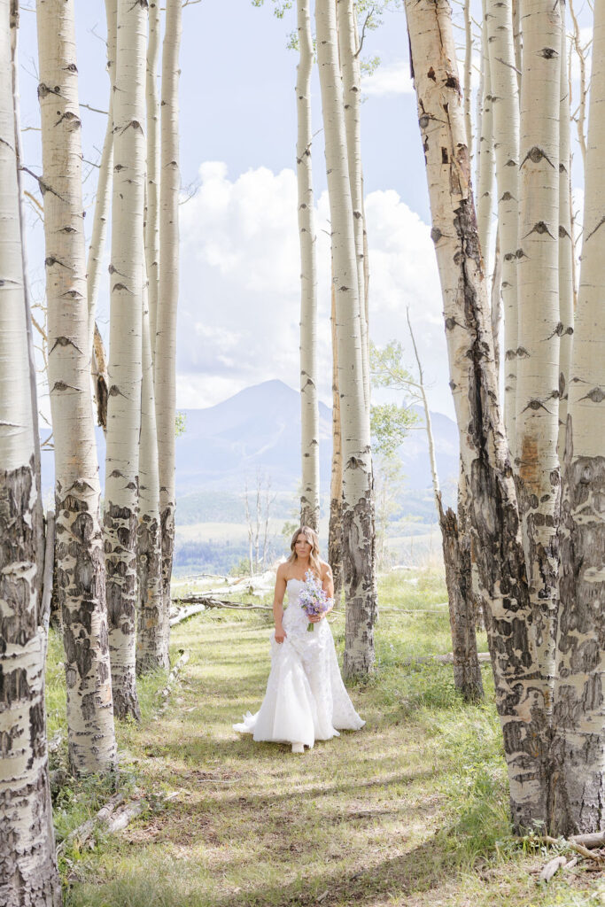 Bride walks through forest of Grand Teton National Park.