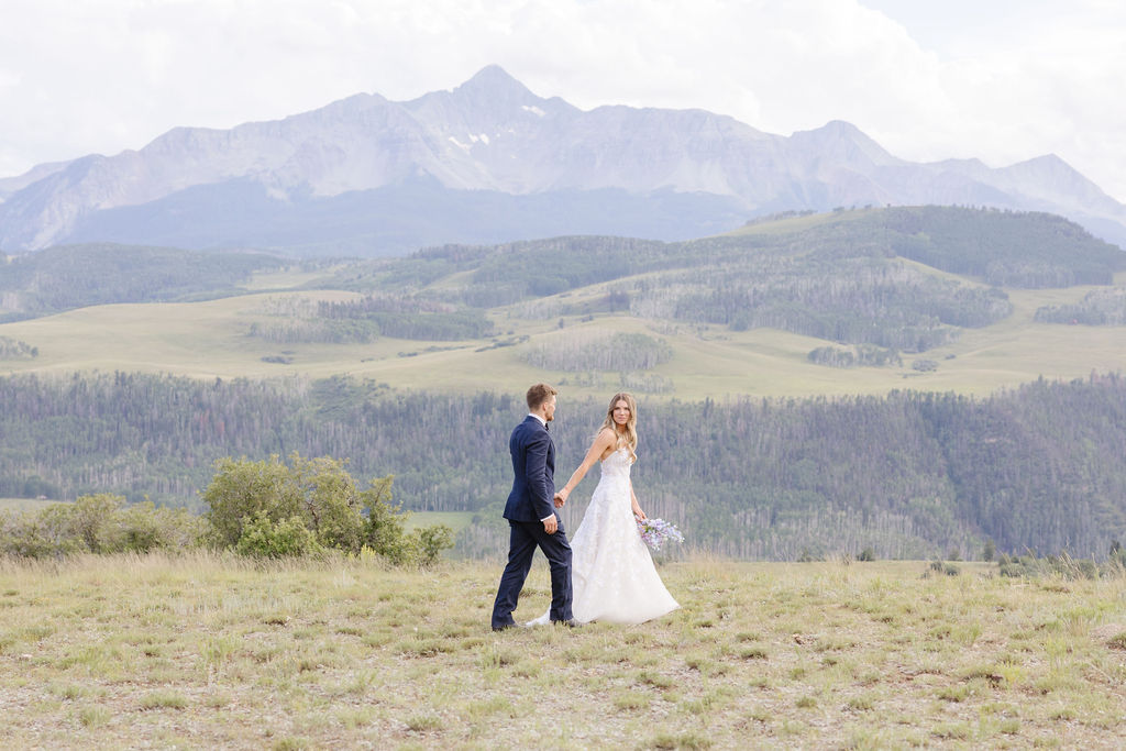 Couple walks through forest after exchanging vows in one of the best places to elope, Grand Teton National Park.