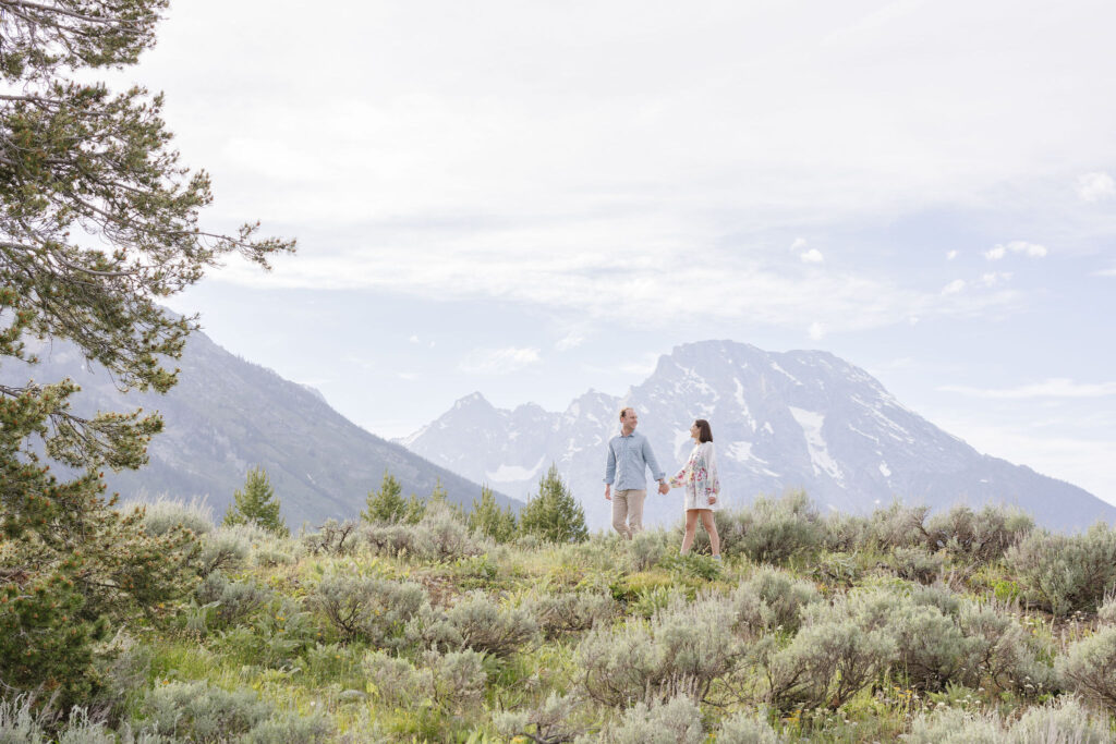 Couple walk in Grand Teton National Park for engagement photos.