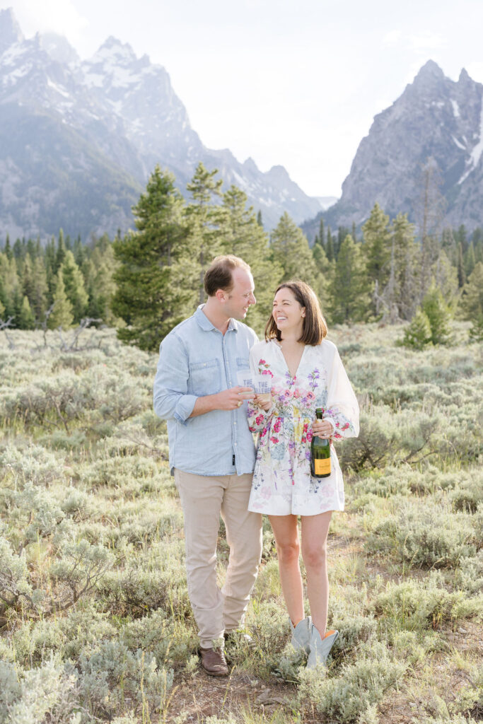 Couple popping champagne during engagement photos in GTNP.