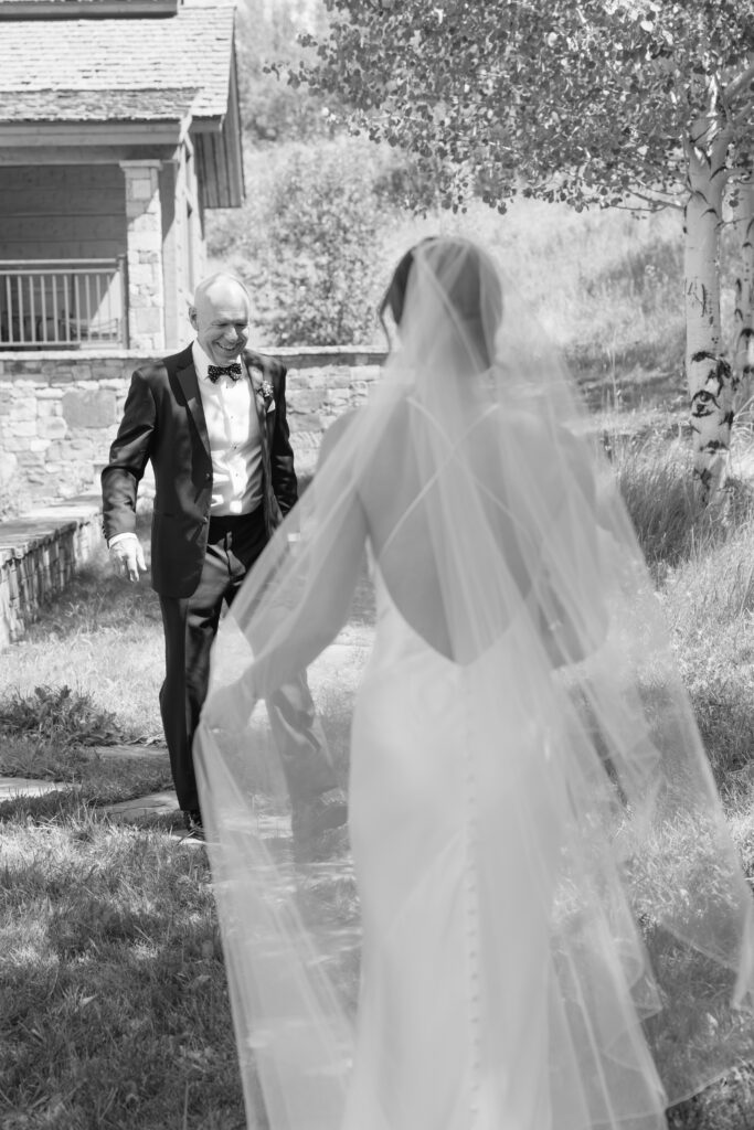 Catholic wedding photographer in Jackson Hole captures first look with bride and father.