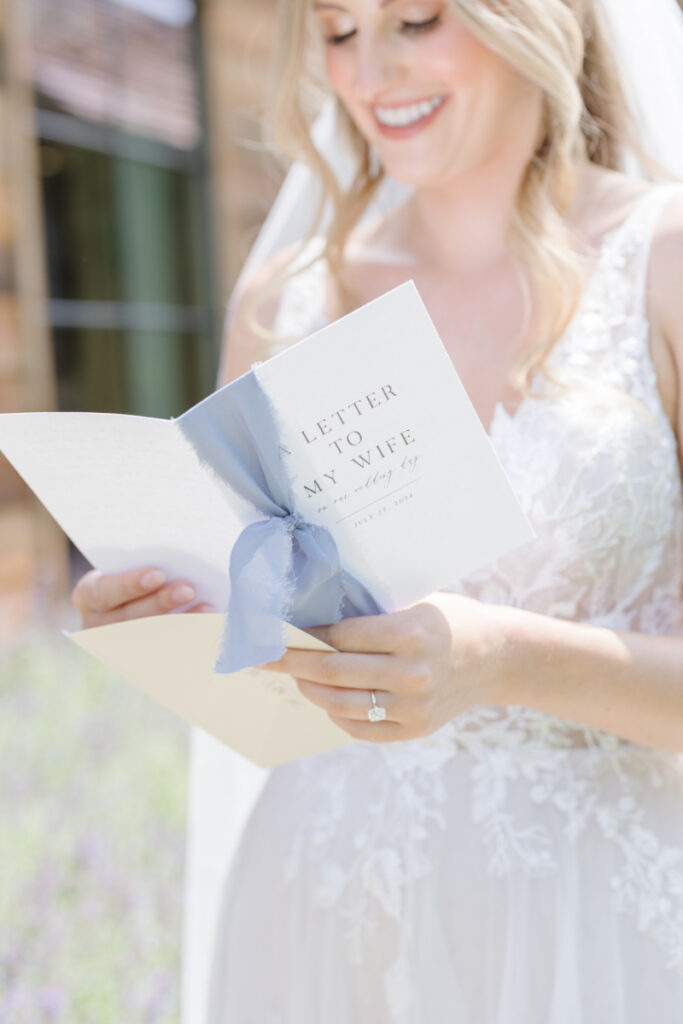 Photographer captures bride reading a letter from her husband before they share their first look.