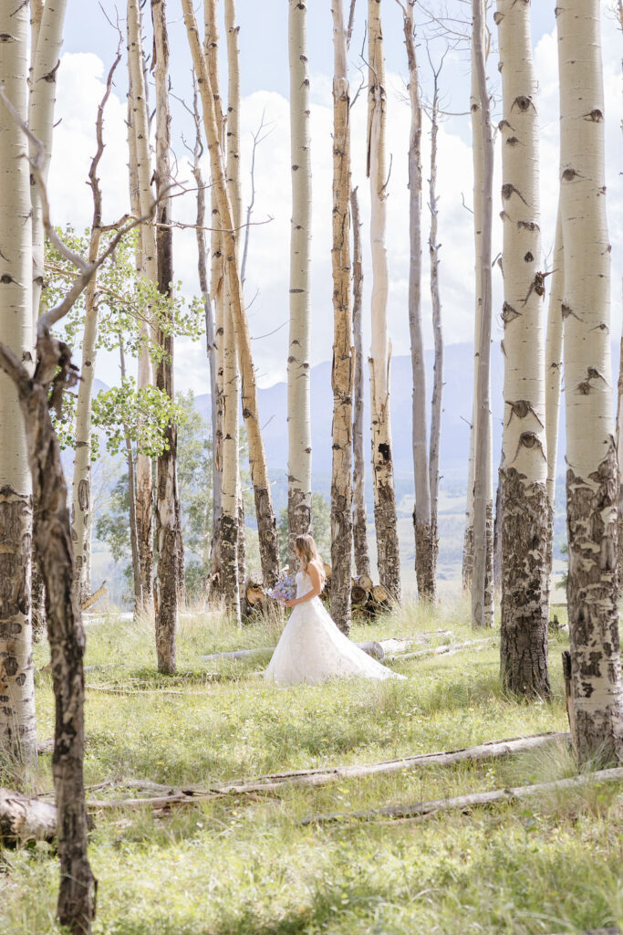 Bride walks through birch trees during elopement in the Tetons.