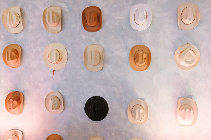 Wall of cowboy hats for Wyoming wedding reception.