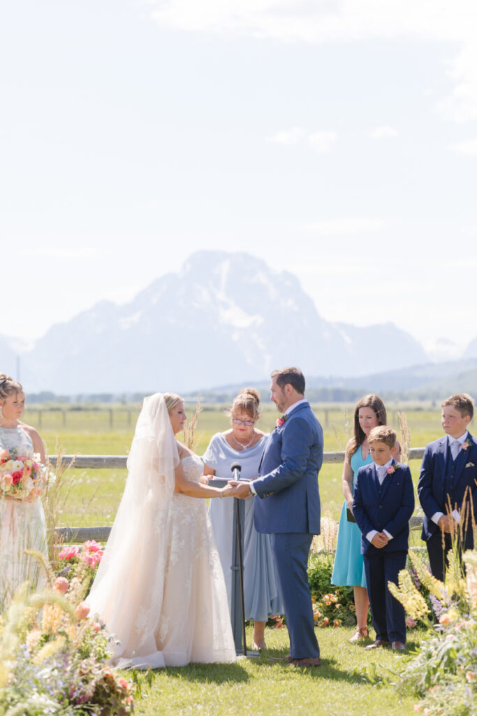 Bride and groom exchange vows with beautiful views of the Tetons as the backdrop of their Wyoming elopement.