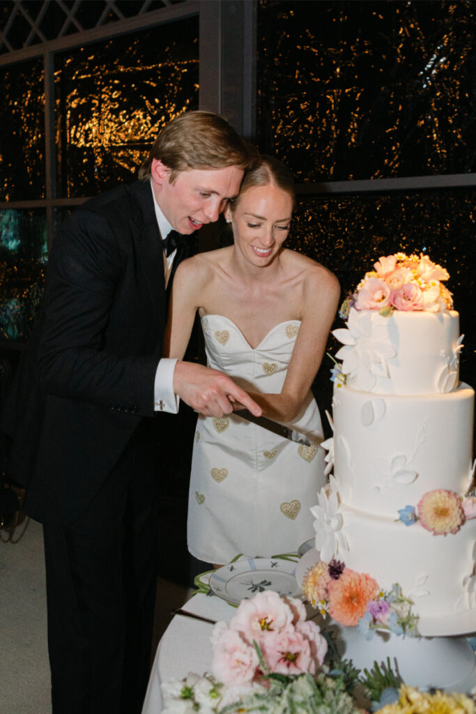 Bride and groom cut the cake together. 
