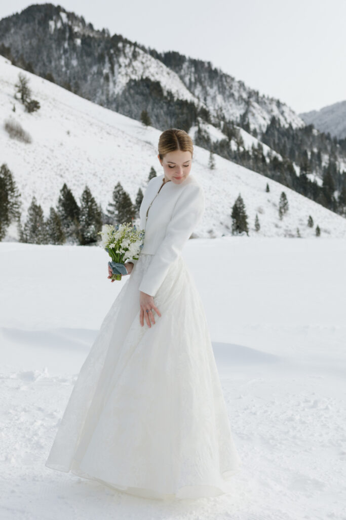 Bride twirls dress during snowy Wyoming winter.