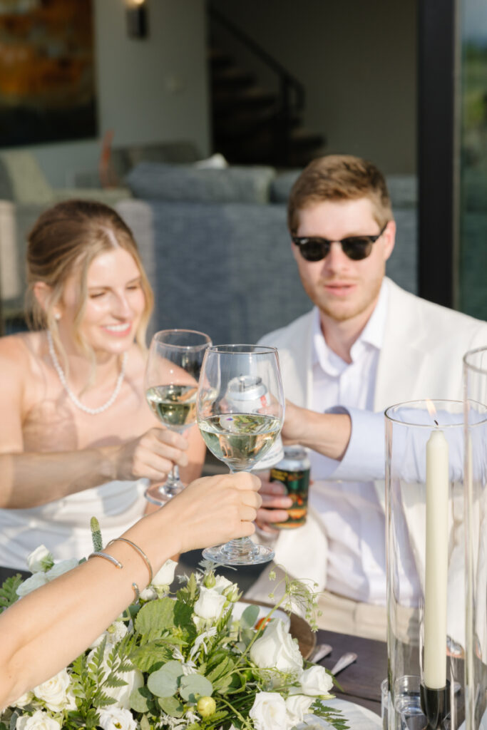 Bride, groom and guests toast their glasses during wedding welcome party.