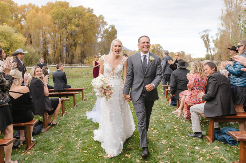Jackson Hole photographer captures fall wedding ceremony as bride and groom leave.