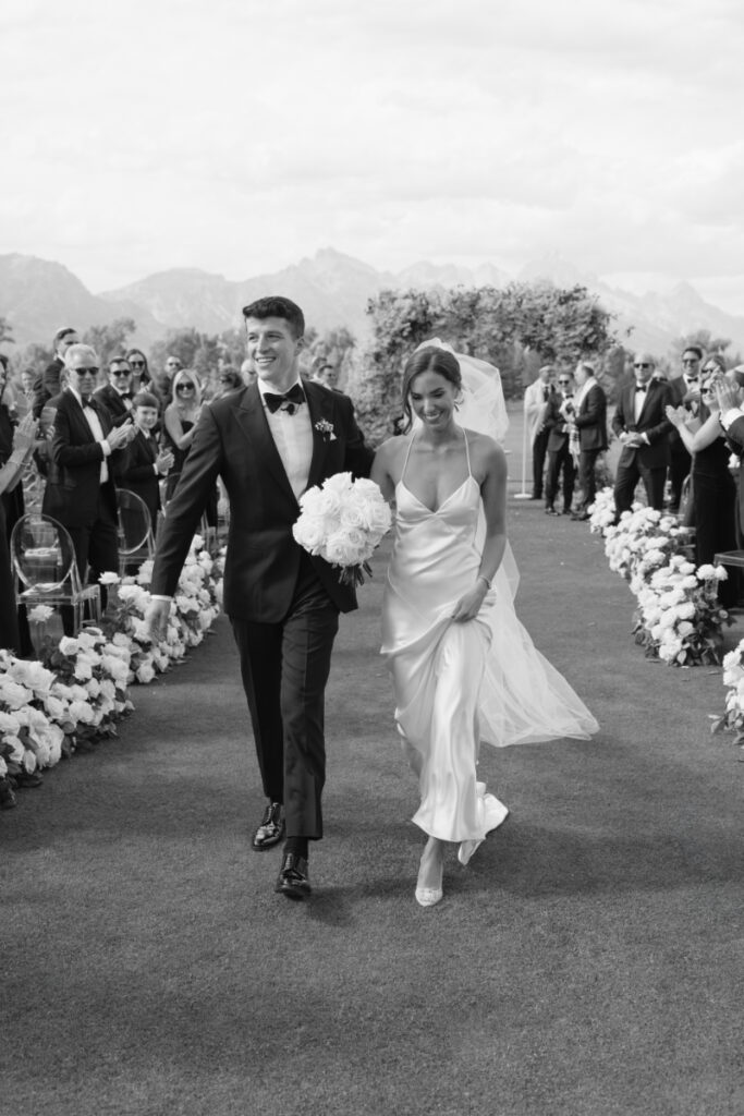 Bride and groom exit ceremony, after choosing between an elopement vs. wedding.