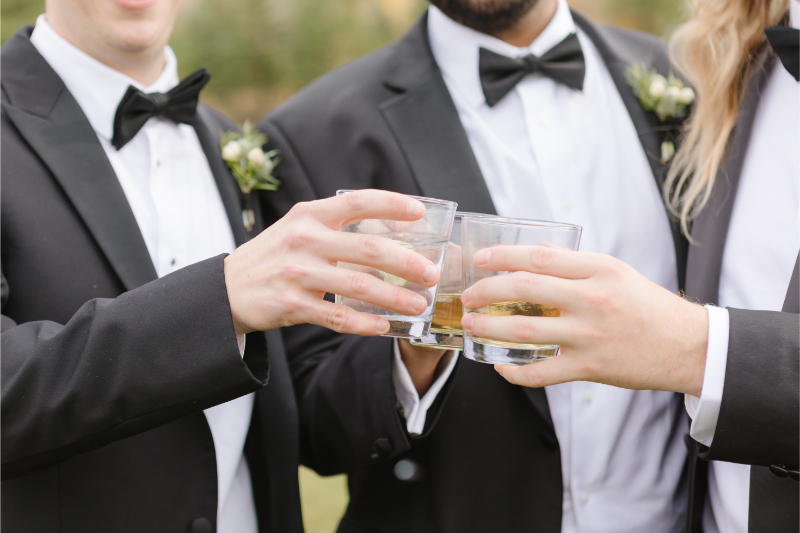 Groom and groomsmen toast with bourbon.