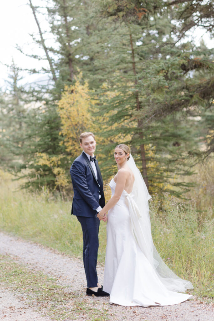 Bride and groom turn around to face photographer during portraits after their Moose Creek Ranch wedding.