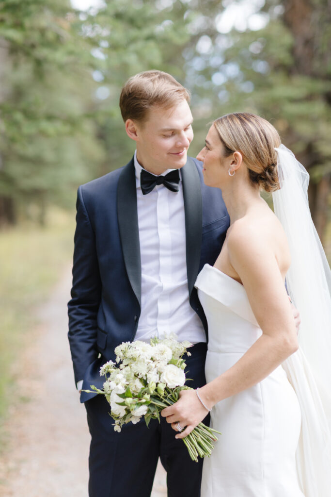 Bride and groom pose for couples portraits after their Moose Creek Ranch wedding.