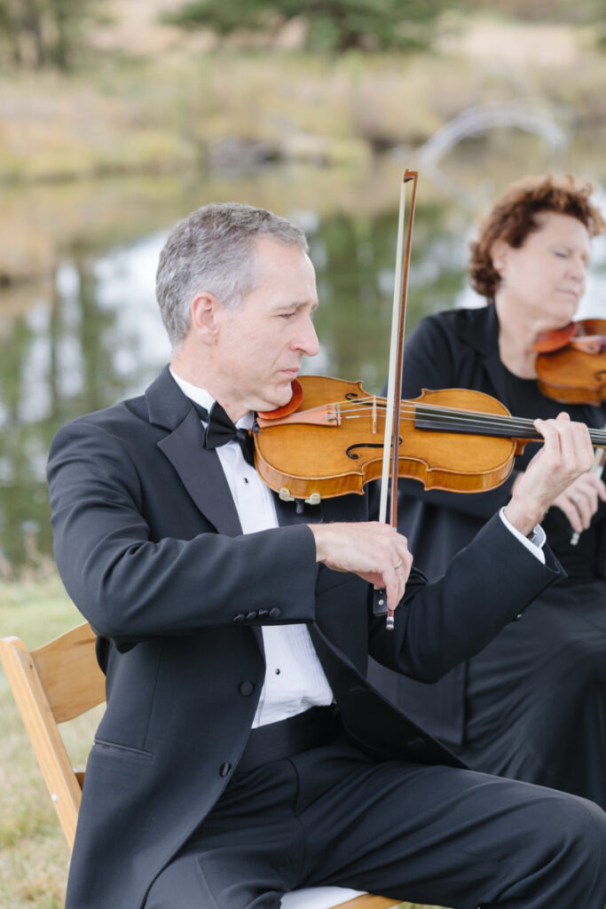 Musician plays violin as wedding ceremony begins.