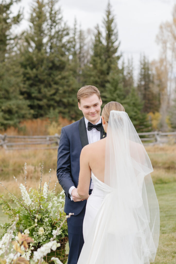 Groom looks at his bride as she reads her vows to him.