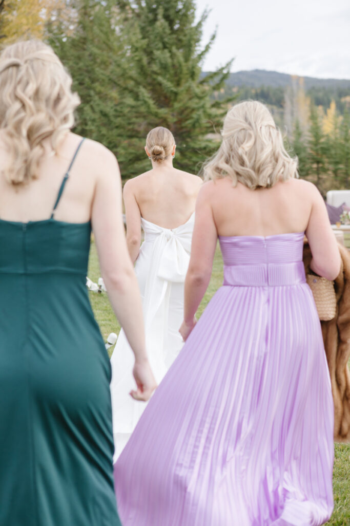 Bride walking ahead of bridesmaids on their way to cocktail hour.