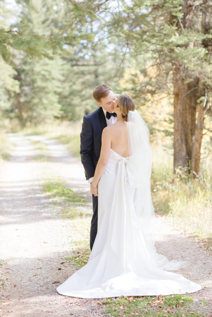 Bride and groom share kiss during couples portraits.