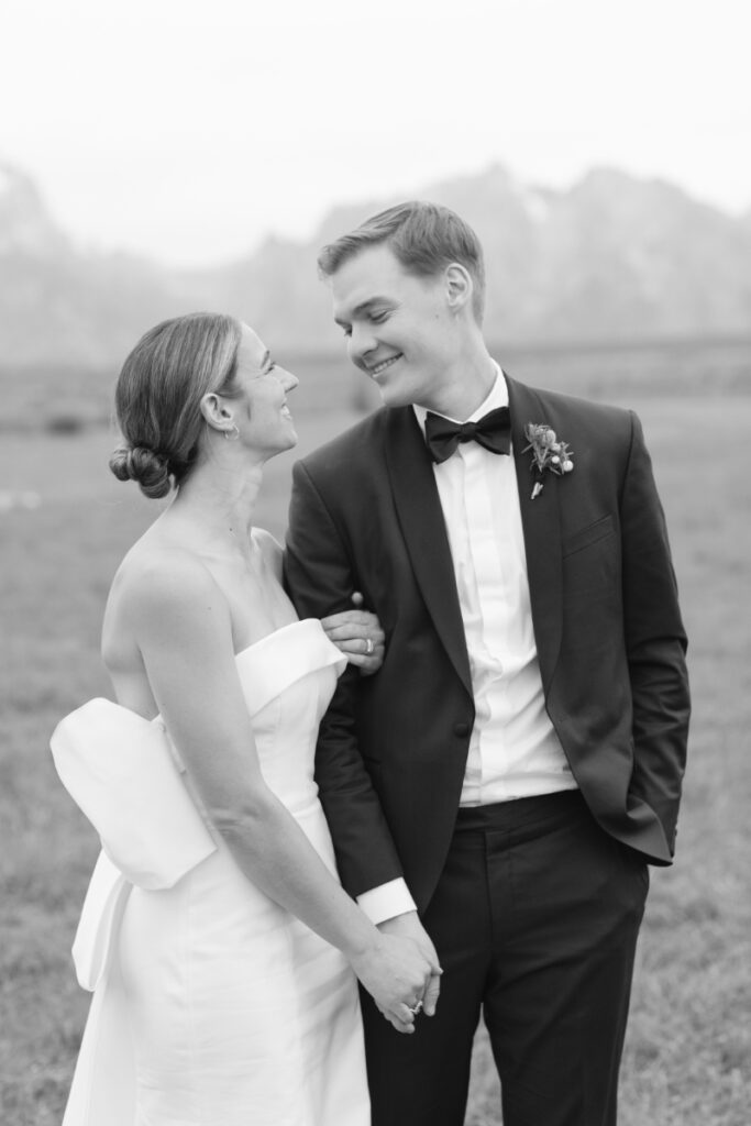 Black and white photo of bride and groom with sweeping views of the Tetons behind them.