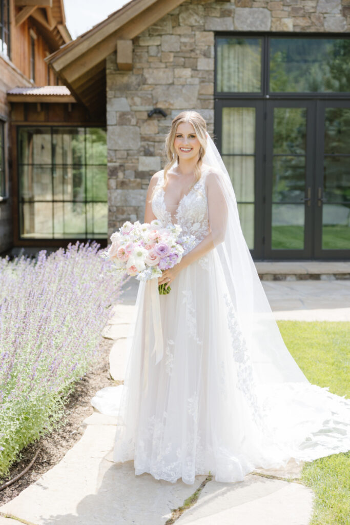 Bride stands for portrait in front of hotel suite.