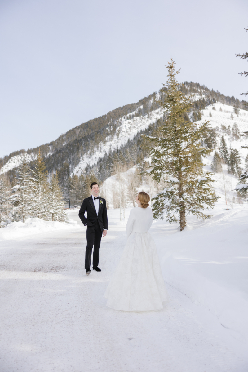 Bride and groom stand in snow covered mountain in Jackson Hole.