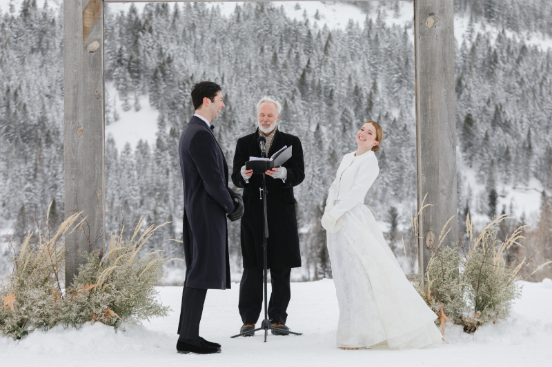 Bride looks out at crowd and laughs during elopement wedding ceremony.