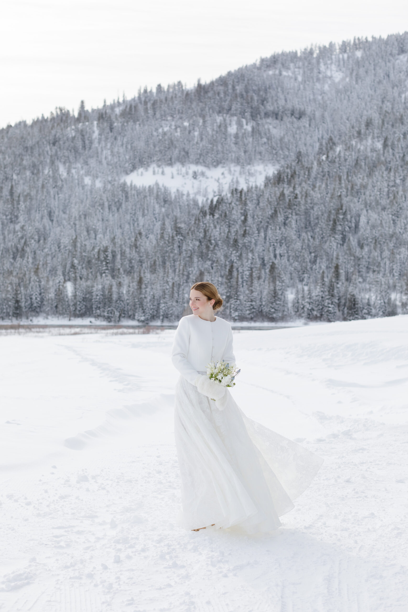 Portrait of bride as she stands in the snow covered Tetons, waiting for her Jackson Hole weddings to start.
