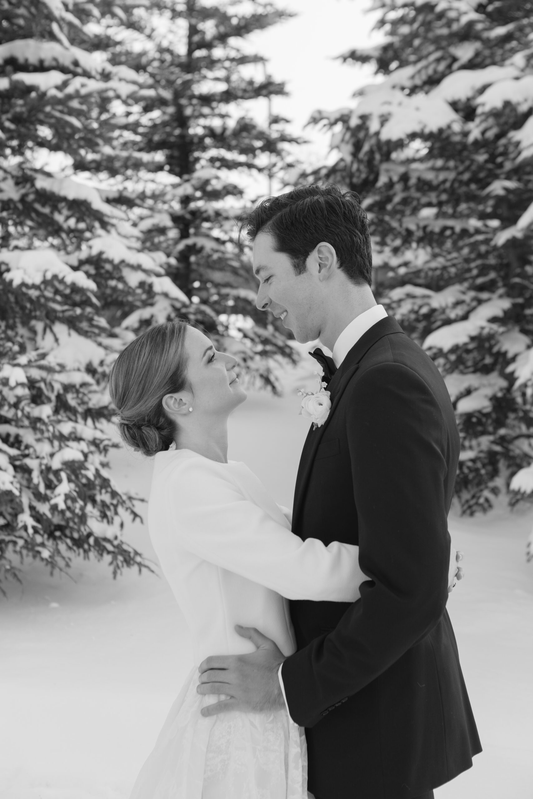 Black and white photo of bride and groom sharing kiss during their first look on their wedding day.