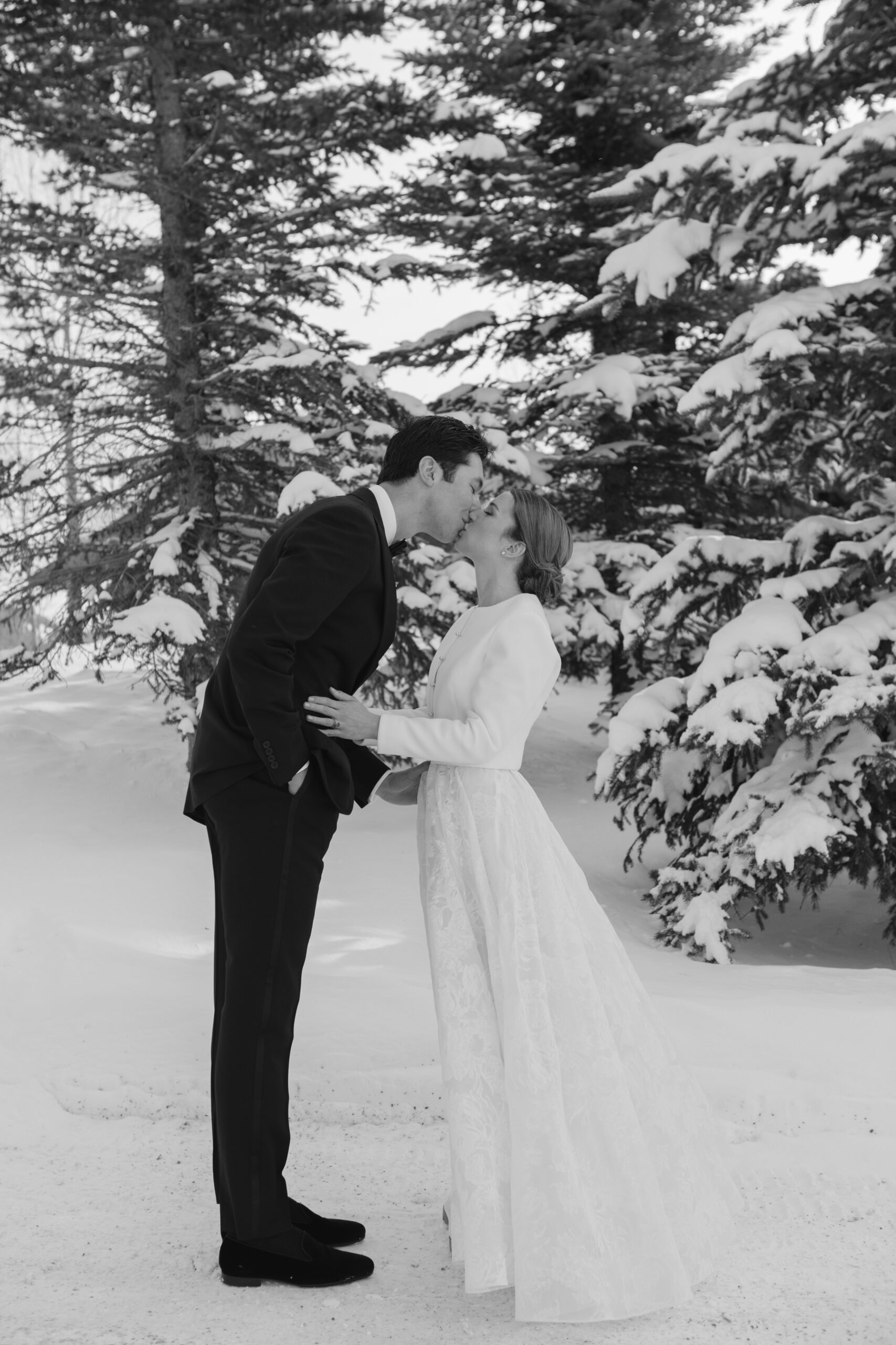 Black and white photo of bride and groom sharing kiss during their first look on their wedding day.