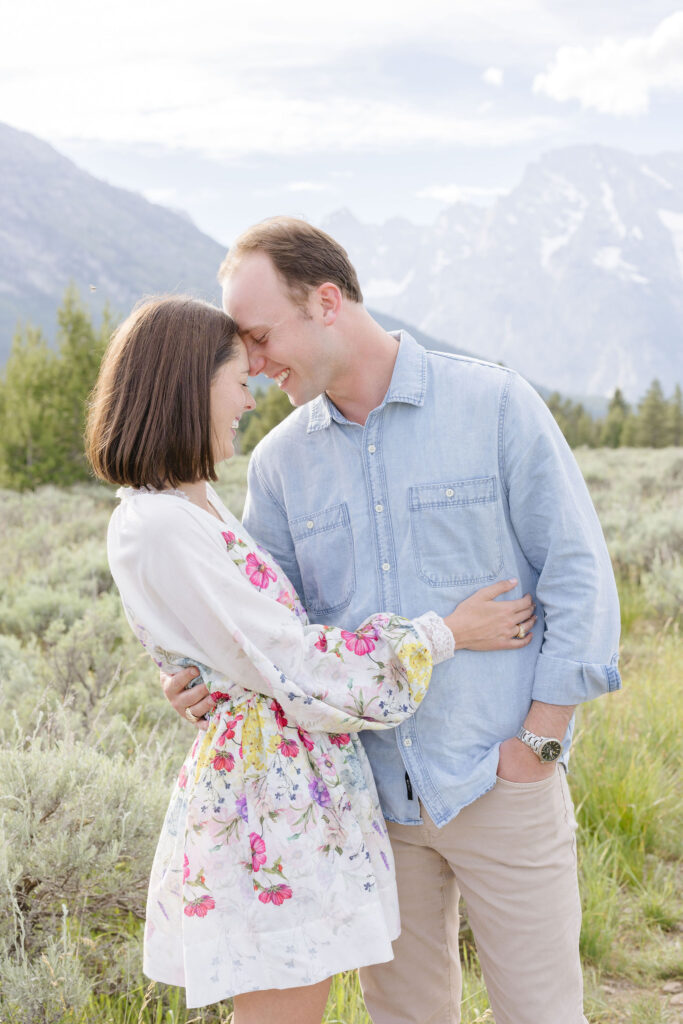 Couple foreheads together with their eyes close and smiling as they pose for their engagement photography at Jackson Hole.