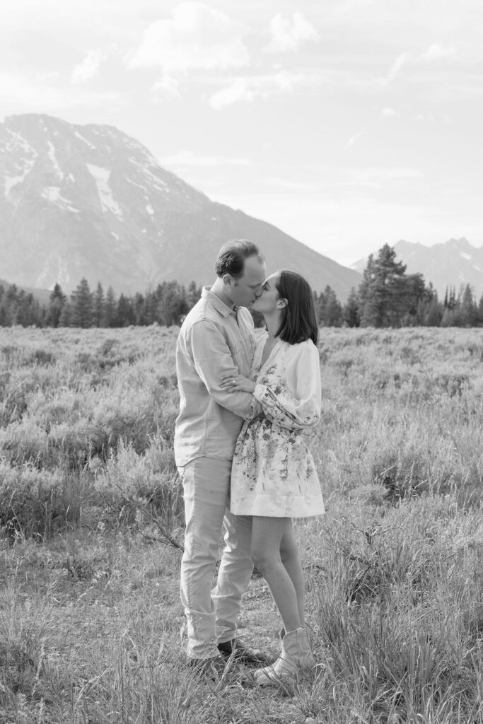 Black and white photo of couple kissing and posing for their engagement photography at Jackson Hole.