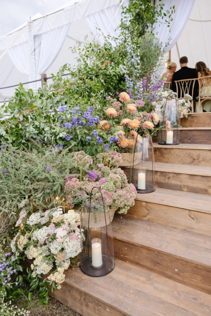 A Yellowstone National park wedding pastel flower arrangement decor for stairs and tent.