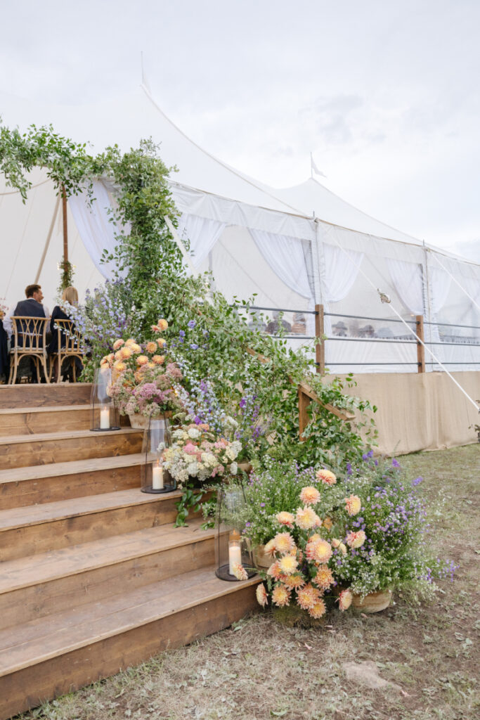 A Yellowstone National park wedding pastel flower arrangement decor for stairs and tent.