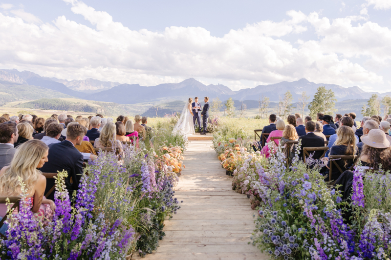 Bride and groom stand together at altar as they exchange vows at. Yellowstone National Park wedding.