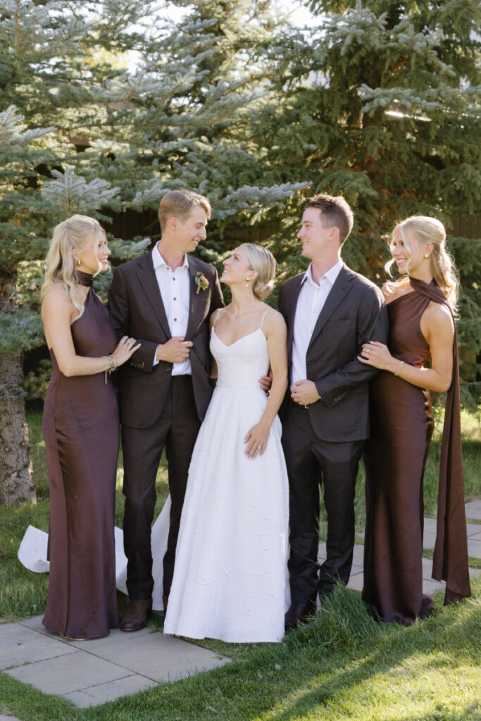 Bride and groom with wedding party posing outdoors during a Grand Teton wedding with natural scenery