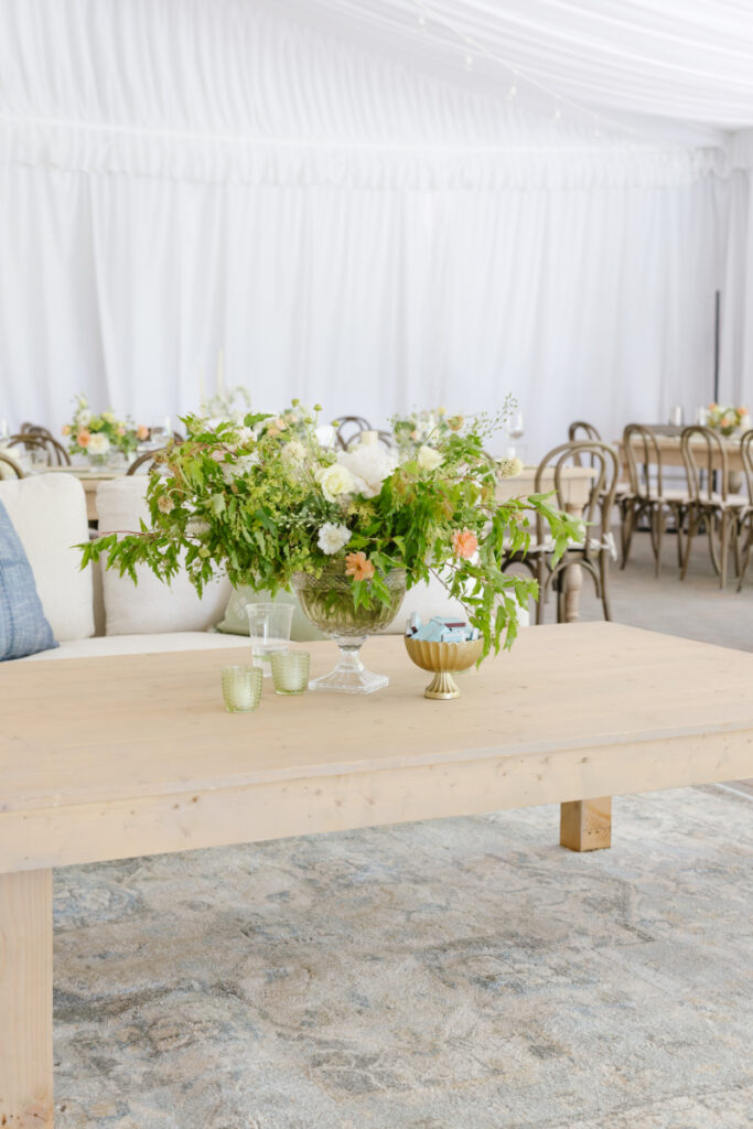 Reception lounge table with floral centerpiece inside a tent at a Grand Teton wedding