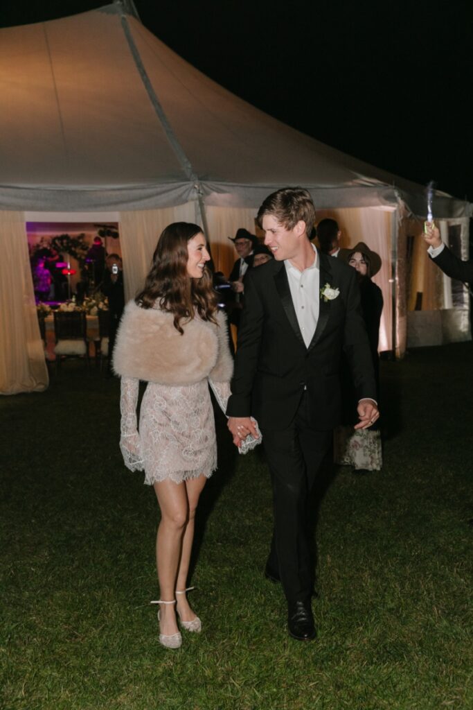 Bride and groom walking into evening reception under tent lighting, Jackson Hole Photographers