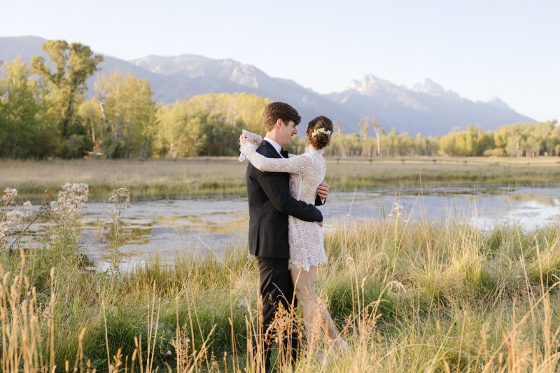 Romantic sunset portrait of couple embracing in field with mountain views, Jackson Hole Photographers