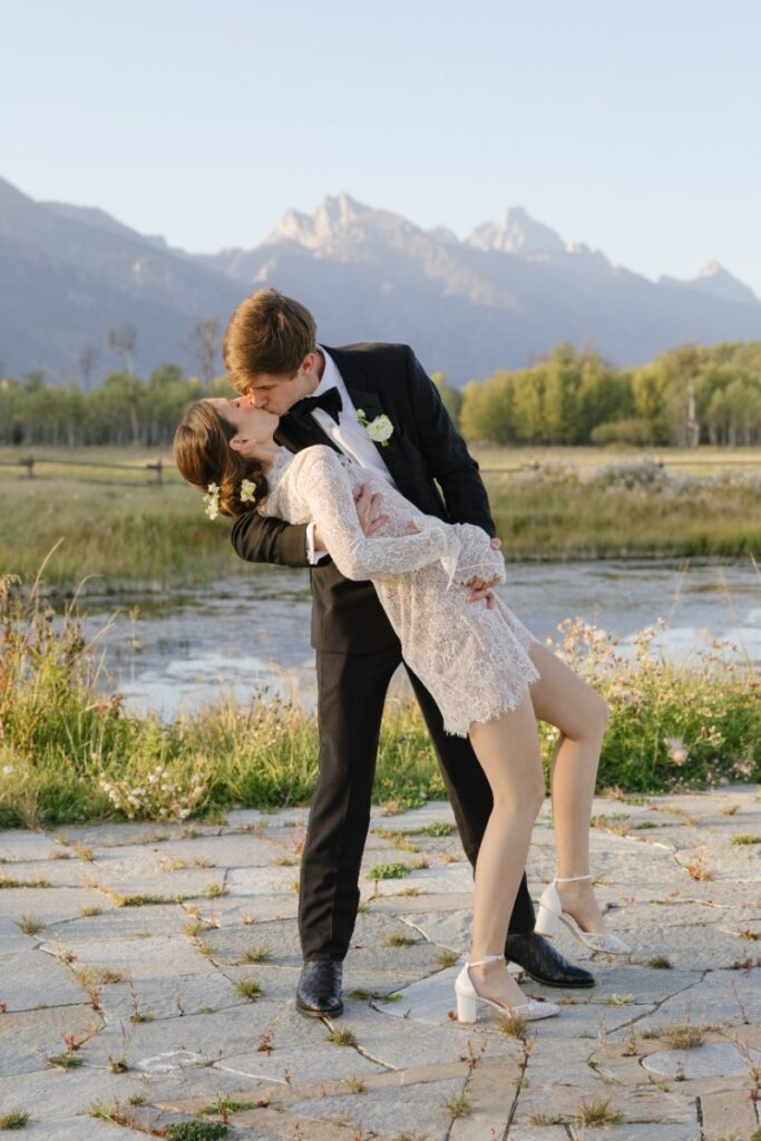 Couple sharing a dip kiss during sunset with mountain backdrop, Jackson Hole Photographers