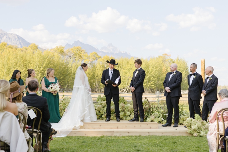 Bride and groom exchanging vows during outdoor ceremony with mountain views, Jackson Hole Photographers