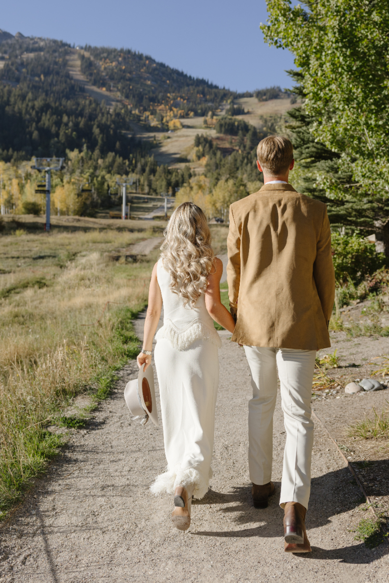 Couple walking toward the mountains as the Snake River overlooks at the Grand Tetons.